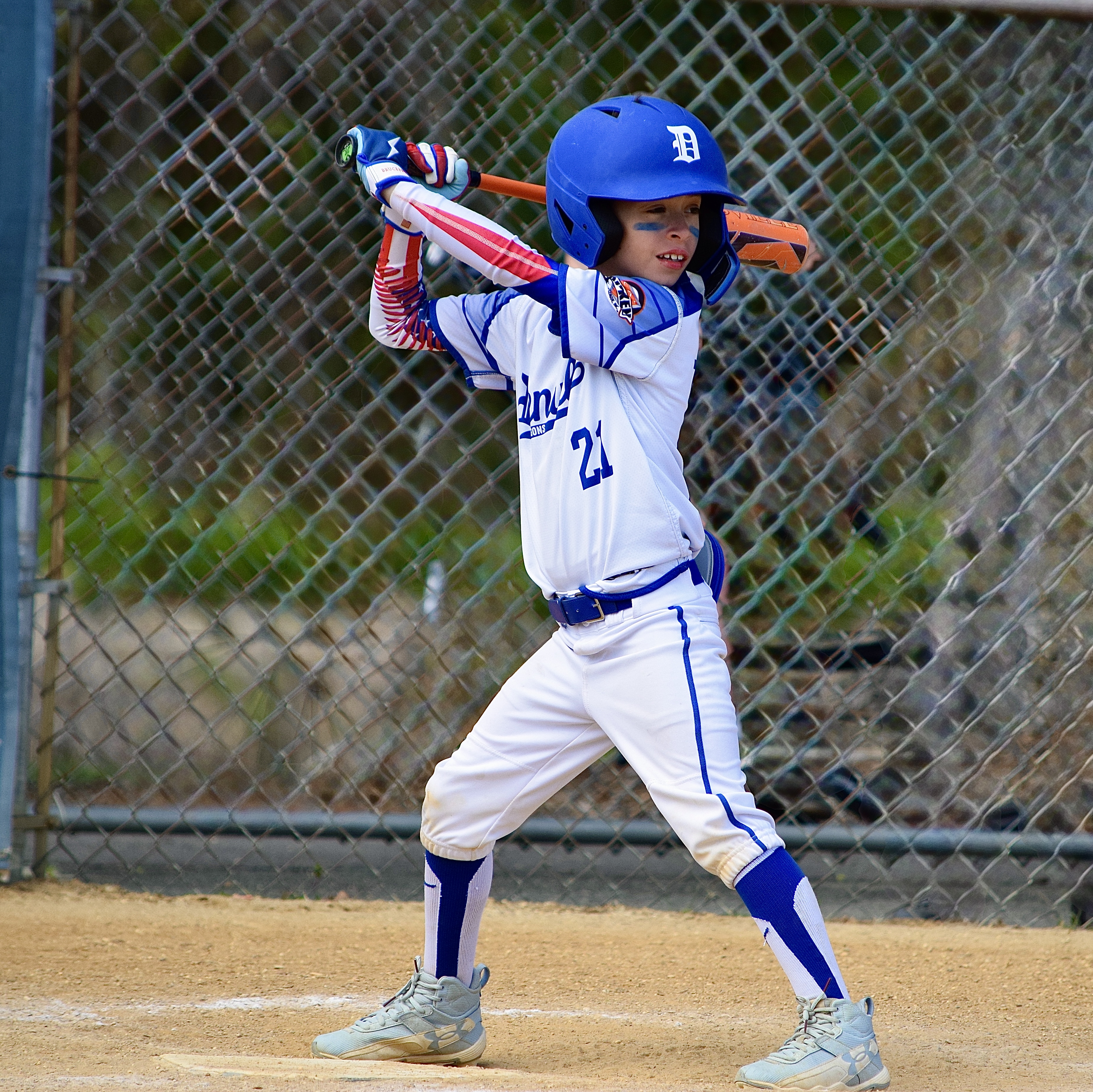 Youth baseball player #21 in batting stance at home plate
